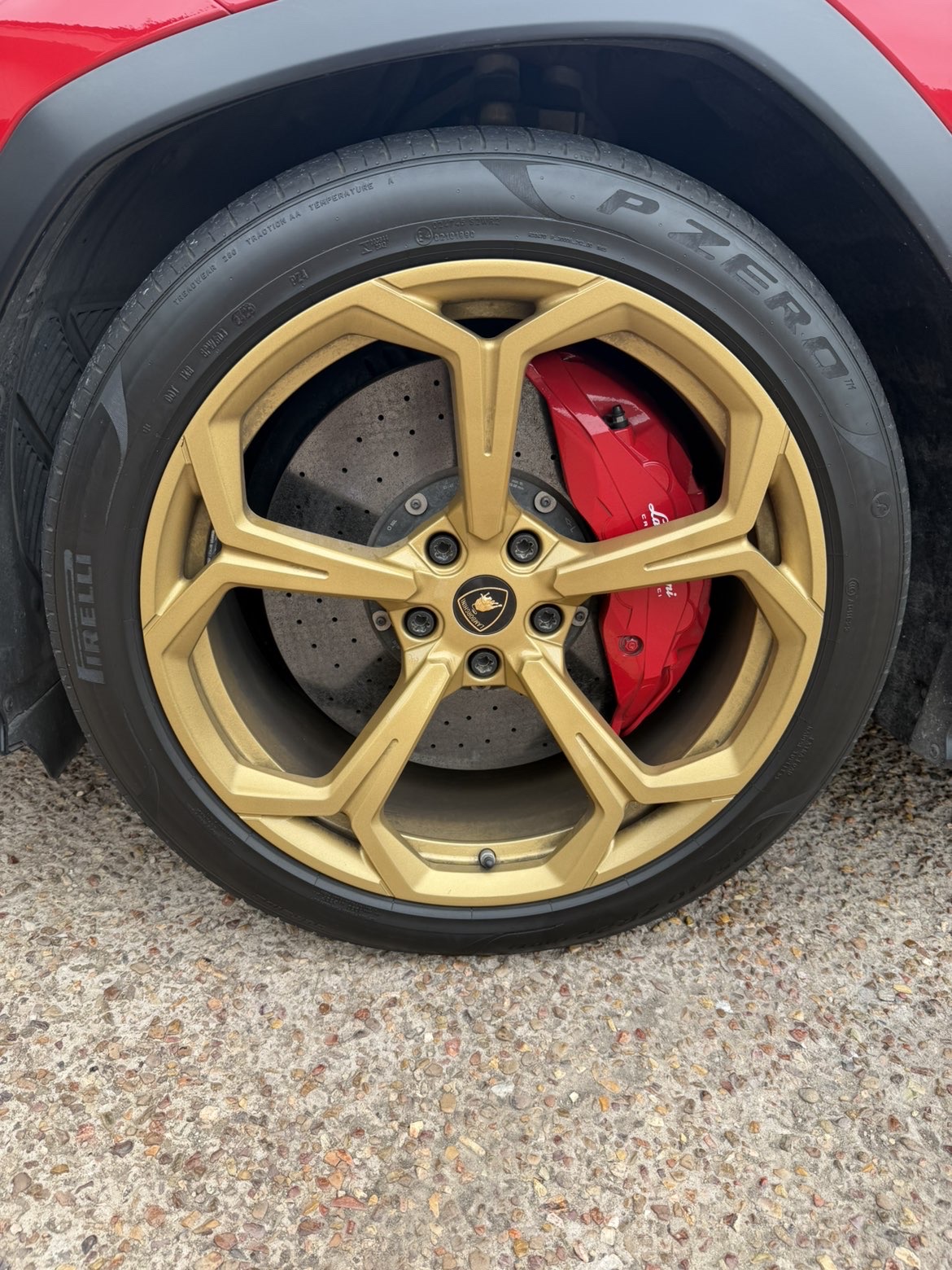 Gold forged Lamborghini wheel and red brake caliper detail